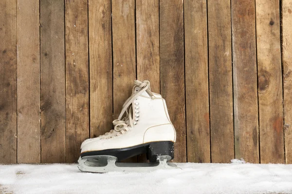 Schlittschuhe gegen eine verwitterte Holzwand — Stockfoto