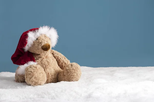 Медвежонок в шапке на Рождество, сидящий в снегу — стоковое фото