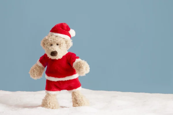 Teddybeer met xmas hoed staande in de sneeuw, — Stockfoto