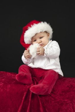 Noel şapka, kırmızı bir yastık üzerinde oturan küçük bebek