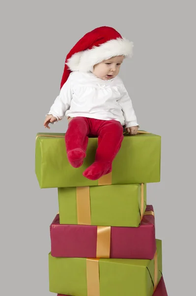Dziecko siedzi na stos Boże Narodzenie prezenty — Zdjęcie stockowe