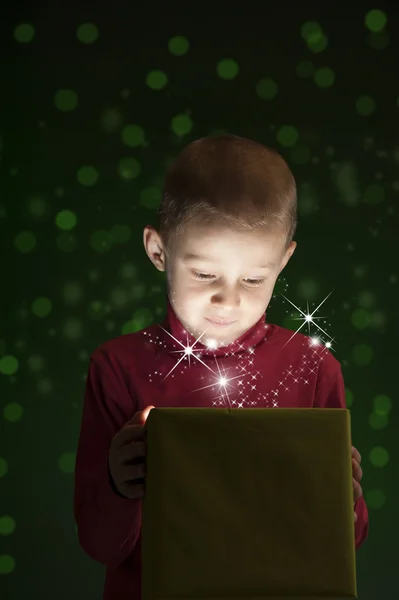 Хлопчик з подарунком, світло виходить з коробки — стокове фото