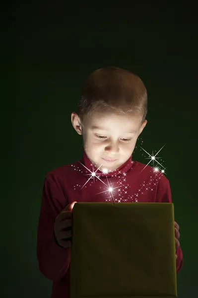 Menino com presente, luz saindo da caixa — Fotografia de Stock