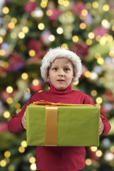 Criança com presente de Natal e chapéu — Fotografia de Stock