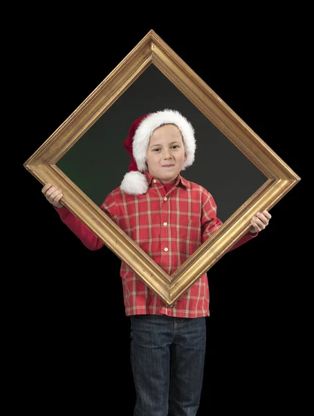 Menino com chapéu de xmas segurando uma moldura dourada, em preto — Fotografia de Stock