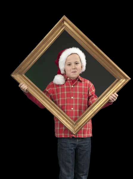 Menino com chapéu de xmas segurando uma moldura dourada, em preto — Fotografia de Stock