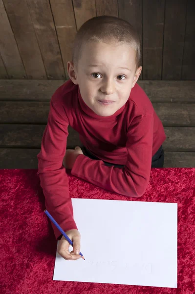 Küçük çocuk Noel için bir mektup yazma — Stok fotoğraf