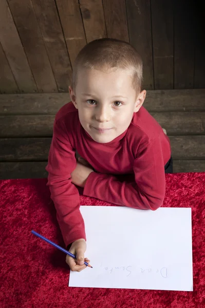 Kleiner Junge schreibt einen Brief für den Weihnachtsmann — Stockfoto