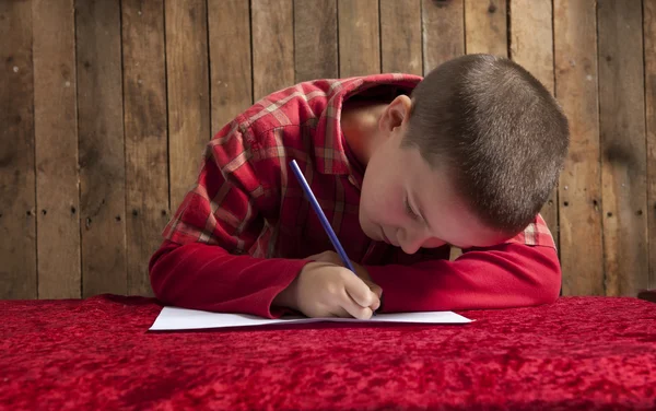 Menino escrevendo uma carta para o Papai Noel — Fotografia de Stock
