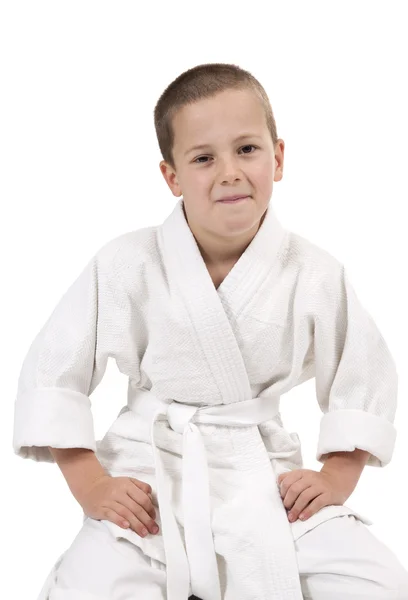 Seated boy in judo kimono on white — Stock Photo, Image