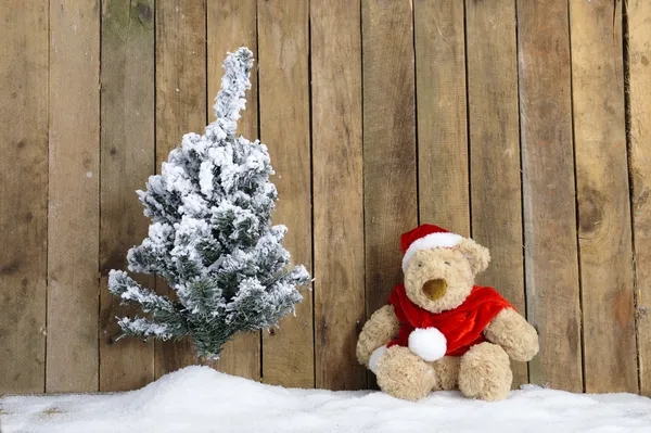 Рождественский плюшевый мишка сидит в снегу — стоковое фото