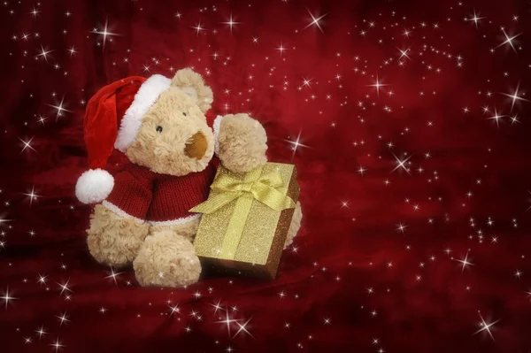 Рождественский плюшевый мишка на красном фоне со звездами — стоковое фото