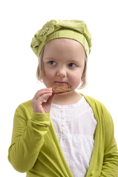Holčička jíst čokoládová cookie. — Stock fotografie