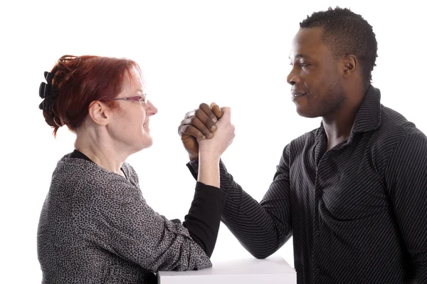 Mature white woman doing arm wrestling with young black man — Stock Photo, Image