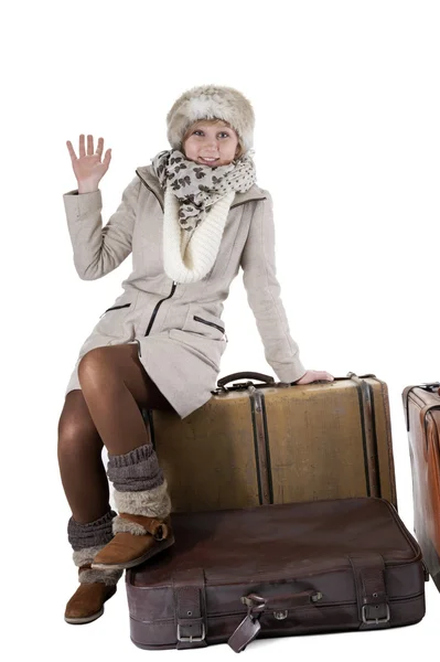 Young woman in winterclothes with suitcases, isolated on white — Stock Photo, Image
