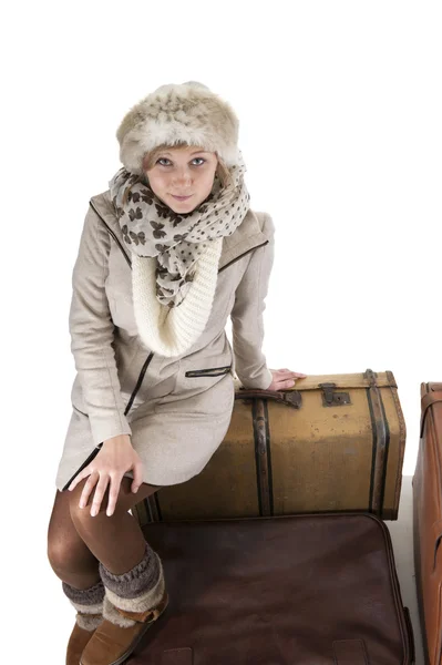 Young woman in winterclothes with suitcases, isolated on white — Stock Photo, Image