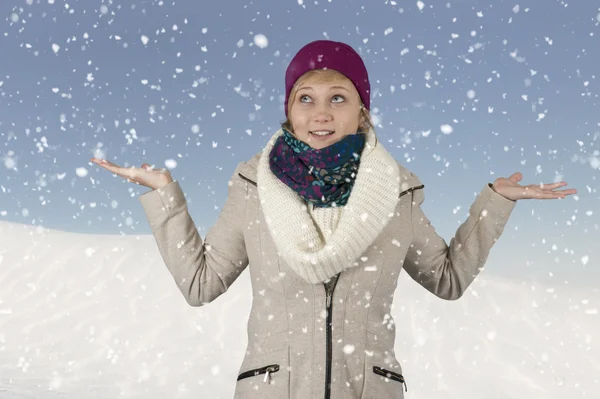 Es schneit auf einer jungen Frau mit Hut und Schal — Stockfoto