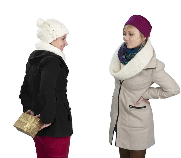 Young woman in winter clothes hiding a present behind her back — Stock Photo, Image