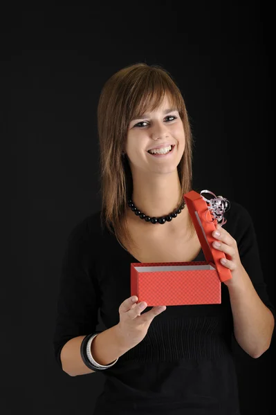 Adolescente abriendo un regalo rojo para su cumpleaños — Foto de Stock