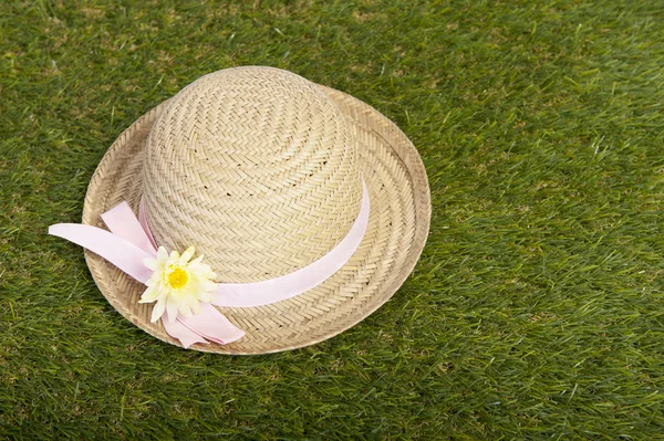 Hoed met bloem liggen op het gras — Stockfoto