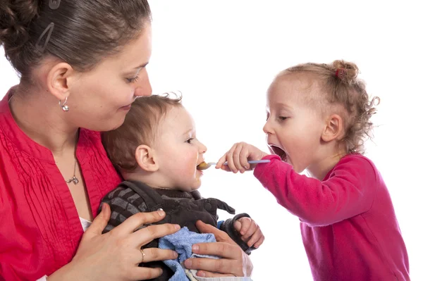 Menina alimentando seu irmão bebê — Fotografia de Stock