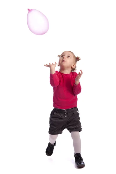 Liten flicka leker med en ballong — Stockfoto