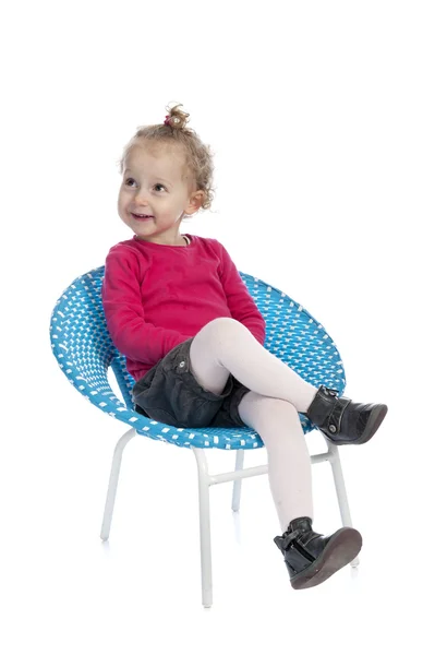 Cute little girl sitting in a round blue chair — Stock Photo, Image