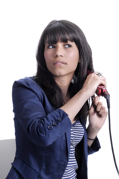 Beautiful young asian woman with hair straightener — Stock Photo, Image