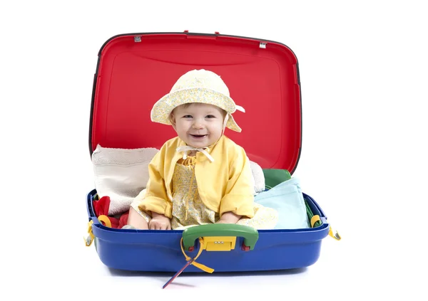 Baby Mädchen sitzt in einem Koffer auf weiß — Stockfoto