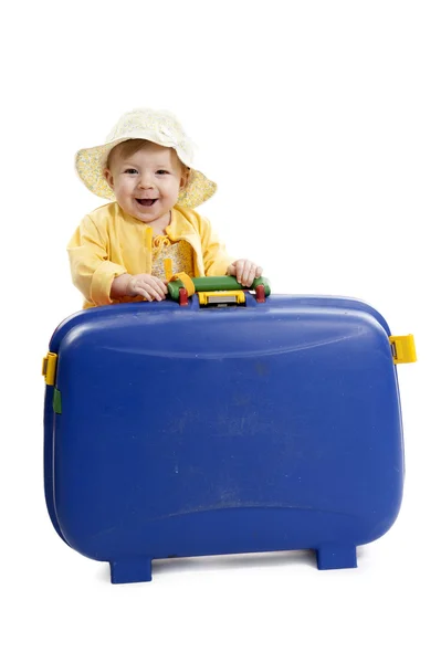 Skrattande bebis med röda och blå resväska, på vitt — Stockfoto