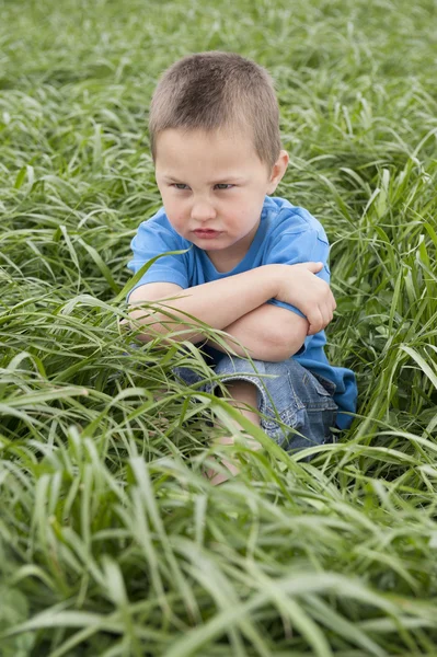 UnhapPy garçon dans prairie — Photo