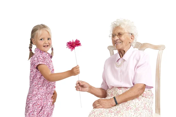 Petite fille donnant à son arrière grand-mère une fleur — Photo