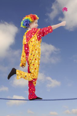 clown as a tightrope walker with flower clipart