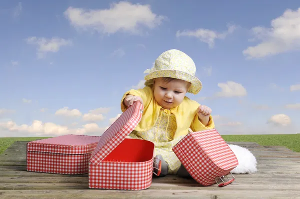 赤と白のビンテージ スーツケースと小さな女の赤ちゃん — ストック写真