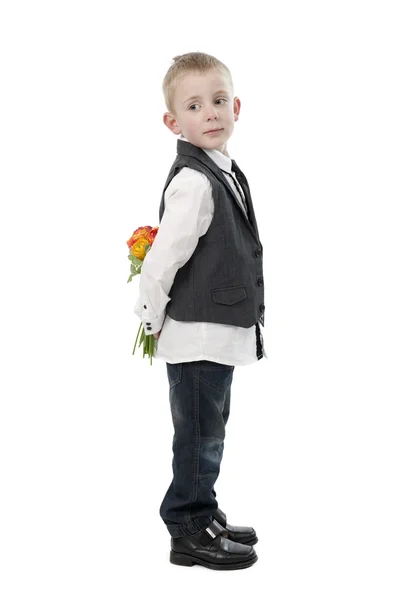 Mother's day, little boy hiding flowers behind his back. — Stock Photo, Image