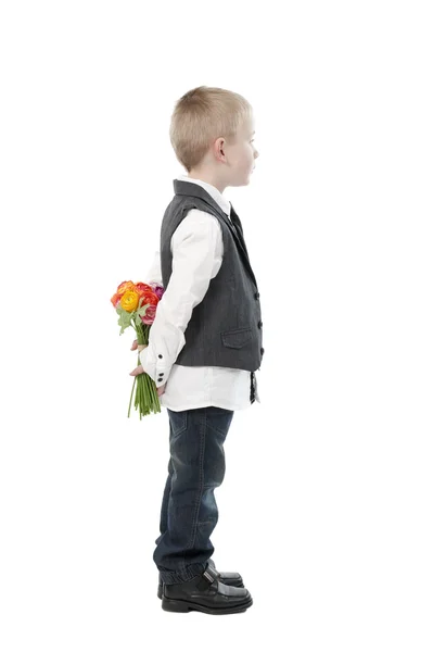 Mother's day, little boy hiding flowers behind his back. — Stock Photo, Image