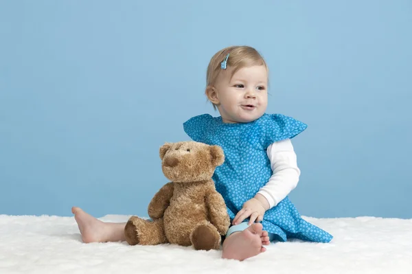 Pequena menina com ursinho de pelúcia, em azul — Fotografia de Stock