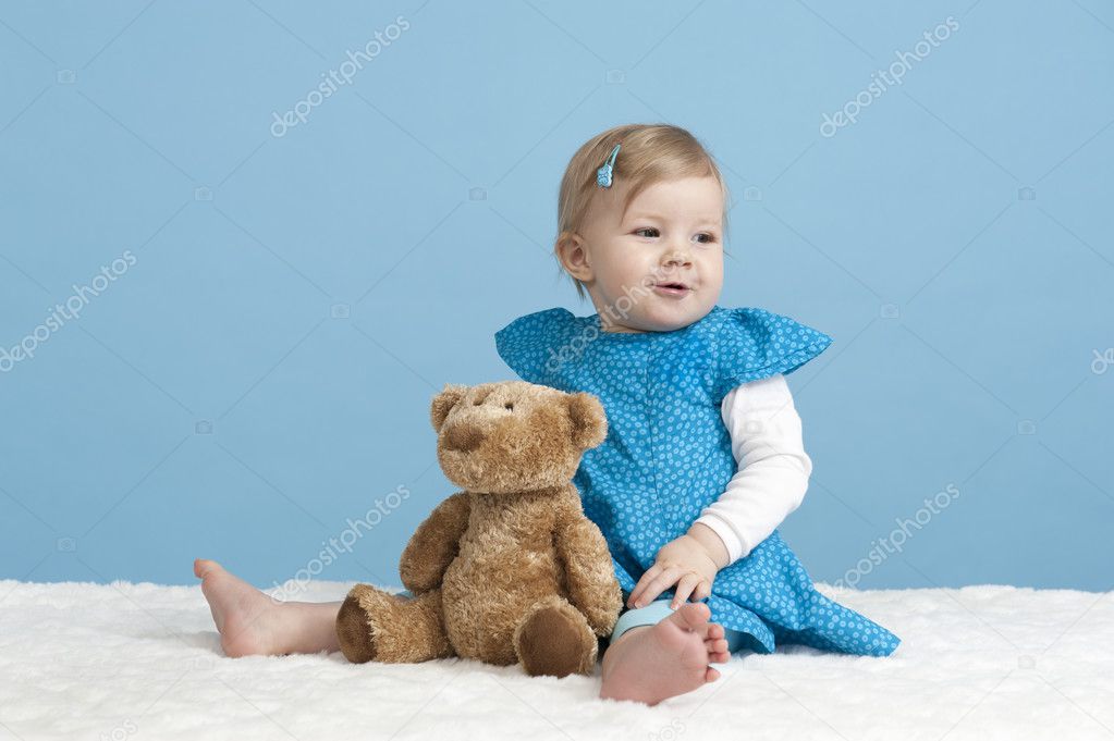little baby girl with teddy bear, on blue