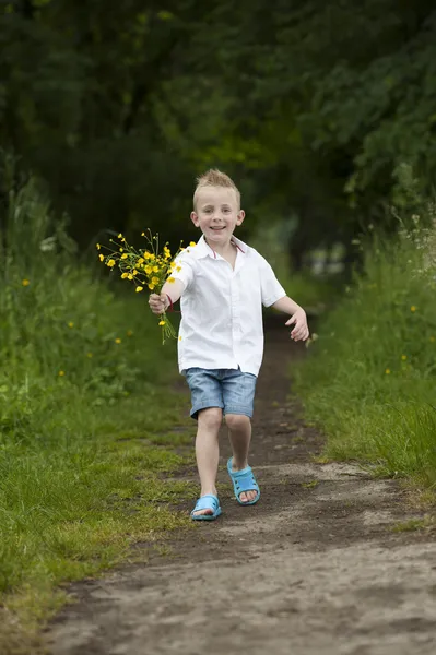 Mors dag: liten pojke med blommor, utomhus — Stockfoto