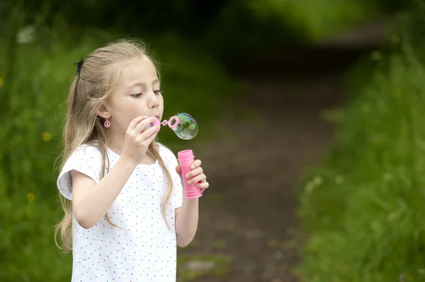 Little girl blowing soap bubbles — Stock Photo, Image