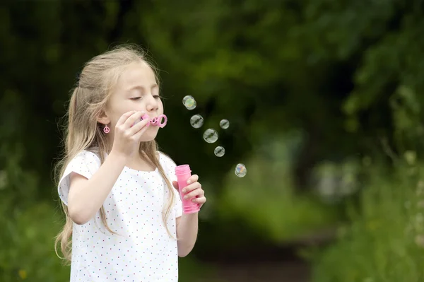 Liten flicka blåser såpbubblor — Stockfoto