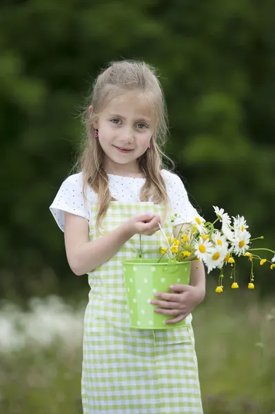 Söt liten flicka skörda blommor — Stockfoto