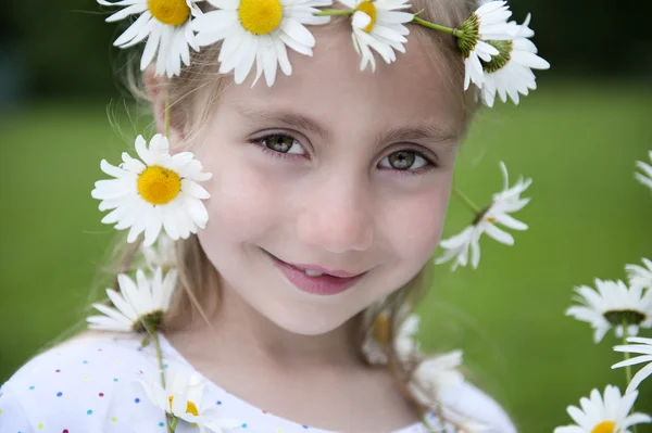 Little girl with daisies in her hair — Stock Photo, Image