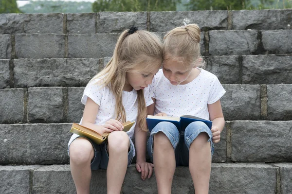 Vacaciones de verano: niños con un libro sentado al aire libre en las escaleras —  Fotos de Stock