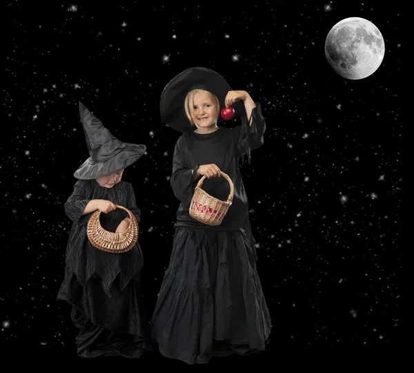 Dvě malé čarodějnice halloween v noci s hvězdami a měsíc — Stock fotografie