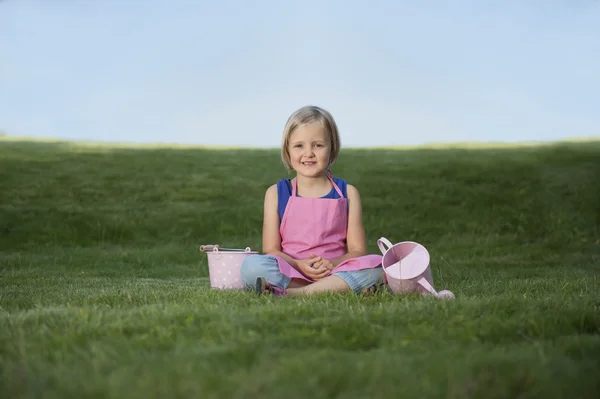 Petite fille avec arrosoir dans le jardin — Photo