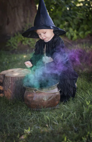 Pequeña bruja de Halloween con couldron al aire libre —  Fotos de Stock