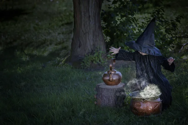 Kleine halloween heks buitenshuis met ketel — Stockfoto