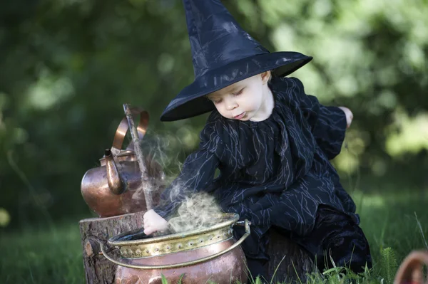 Little halloween witch with couldron outdoors — Stock Photo, Image
