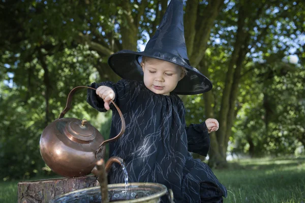 Malá čarodějnice halloween s couldron venku — Stock fotografie